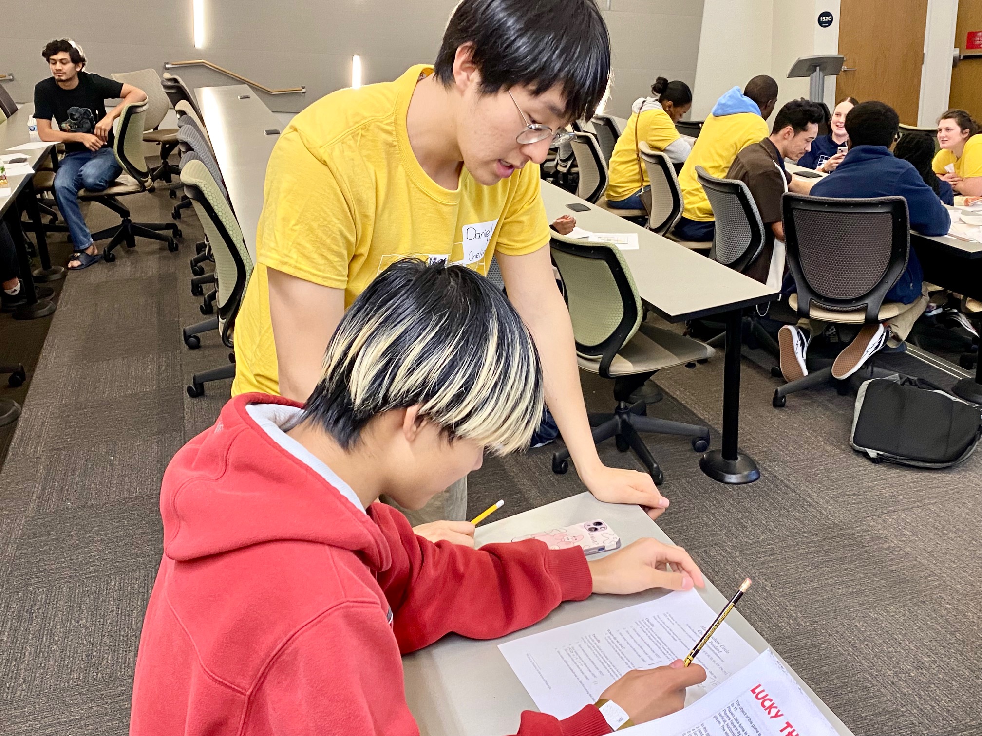 Daniel Hwang, a graduate student in the School of Mathematics, helps Yinuo Song, an 11th grader at Gwinnett School of Mathematics, Science, and Technology, with a logic puzzle. (Photo Renay San Miguel)